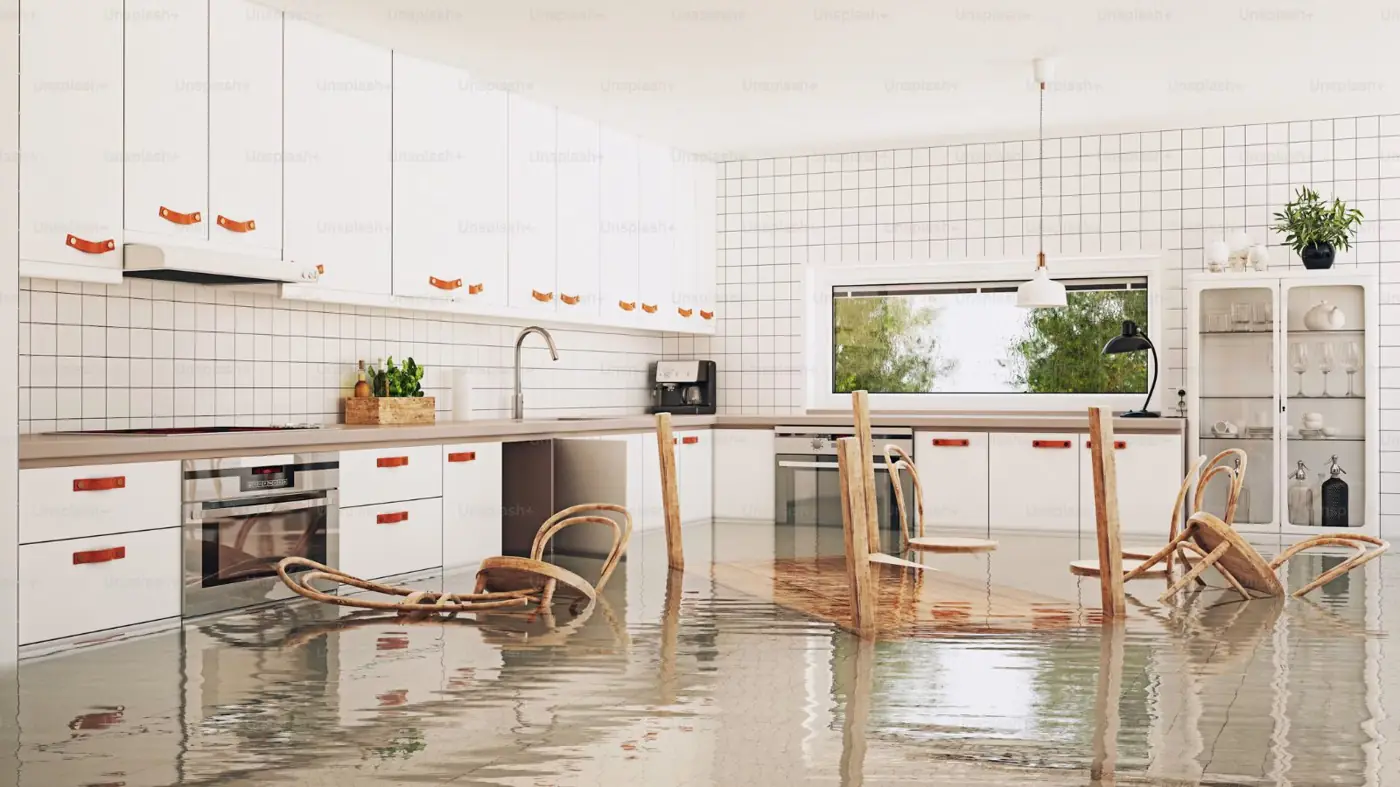 Condo kitchen with water covering the floor and chairs knocked over